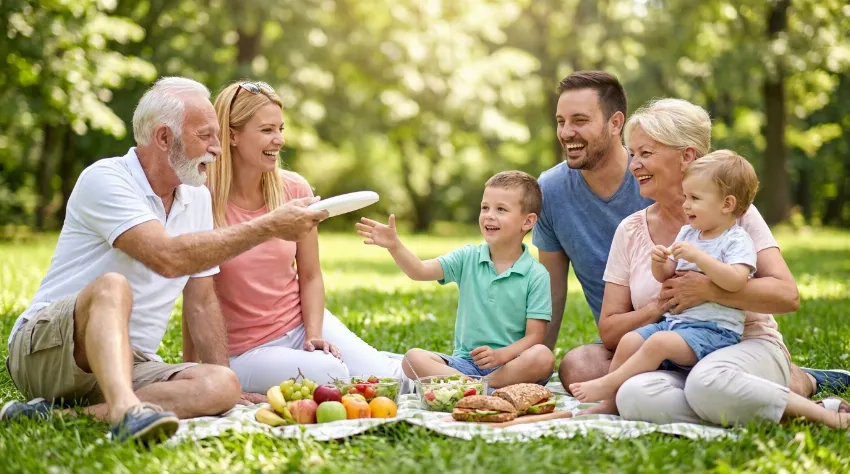 Srečna družina na pikniku v parku.