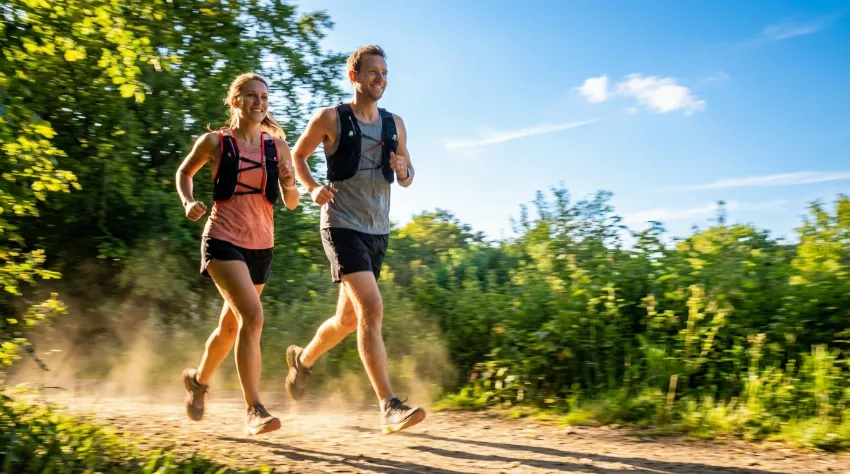 Par teče po parkovni poti na sončen dan.